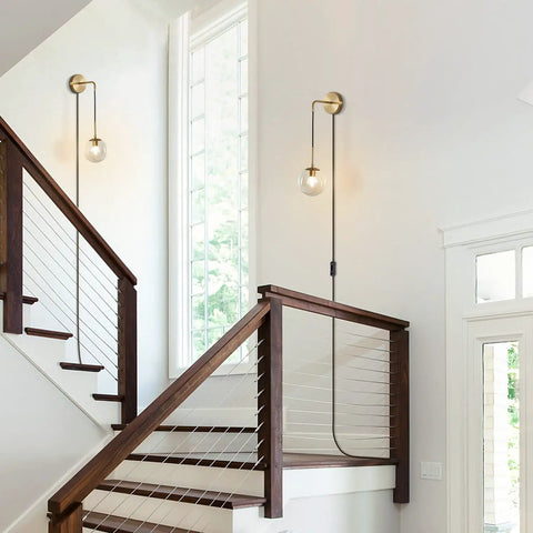 Plug In Wall Sconce Set Of 2 Modern Glass Globe Lights With Brushed Brass Finish in a staircase hallway
