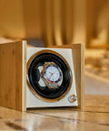 Wooden Dope Watch Winder Box For Automatic Watches, Dual Power Supply Rotating Device, elegantly displayed on a table.