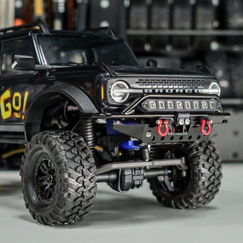 Front And Rear Aluminum Tube Bumper Set For 1/18 TRX4M Bronco Crawler Lightweight Metal Armor With LED Front Bumper For Night Drives Removable Tow Hitch On Rear No Mods Required Fits Stock Body installed on black TRX4M Bronco model, showing LED lights.