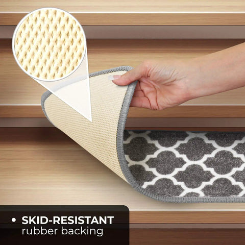 Hand lifting Skid Resistant Carpet Stair Treads Set Of Fifteen With Moroccan Trellis Pattern In Misty Gray And Linen White, showing non-slip rubber backing.