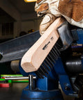 Person using Rugged Wire Scratch Brush With Wood Handle Carbon Steel Bristles For Aggressive Rust And Paint Removal On Metal Surfaces