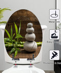 Elongated white zen balance stones bamboo plant wooden table Toilet Seat on a white toilet, showing soft-close feature.