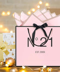 13 Inch Birthday Gift Bag Set with Card Envelope Ribbon Bow and Tissue Paper for Women and Girls Handles includes Greeting Card Milestones from 13th to 100th, pink themed with black handles and bow, festive background.