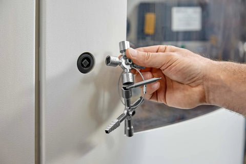 Hand using TwinKey Multifunctional Spanner Kit With Magnetic Eight Arm Two By Four Way Spider Keys on control cabinet