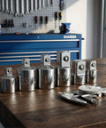 Six Piece Socket Adapter And Reducer Set For One Quarter, Three Eighths, And One Half Inch Drives With Must Have Pro Grade Conversions And Impact Ready Chrome Vanadium Steel Construction displayed on a workbench.