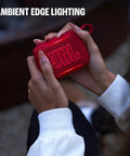 Person holding a red Palm Sized Ultra Portable Waterproof And Drop Proof Bluetooth Speaker With Deep Bass, Ambient Edge Lighting