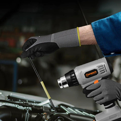 Person using Cordless Heat Gun Kit 20V Max With Lithium Battery on vehicle engine for heat application, showing glove details.