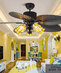 Top Shelf Retro European Ceiling Fan With Remote Control And Striking Stained Glass Shade On A Rock Solid Base Featuring Five Eco Friendly Blades And A Flip Style Reversible Motor To Keep The Good Vibes Rolling In Bedrooms Or Living Rooms At 52 Inches, displayed in a modern living room with yellow walls.