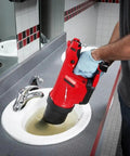 Cordless Drain Cleaning Air Gun Kit With Variable Pressure Control And Quick Swap Auger Tips For Sinks Toilets And Drains Quickly Unblocks Nasty Pipe Clots Fast While Providing Twenty Five Rapid Blast Cycles Per Charge For Pros Only in use over a clogged sink.