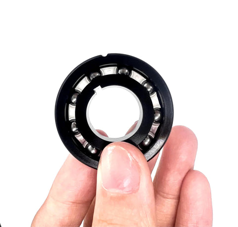 Turbine bearing for pool vacuum cleaner, black circular ring with inner bore and visible steel balls.