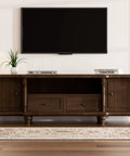 Wooden TV cabinet with closed shelves and drawers under a wall-mounted flat-screen TV in a modern living room.