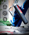 FOTU grease gun with red grease tube in use, gloved hands handling the nozzle.
