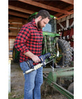 Person using Lincoln 1134 Pistol Grip Grease Gun Kit With 18 Inch Hose And 6 Inch Rigid Extension 5900 PowerLock Lever Action Coupler