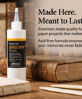 Bottle of Neutral pH All Purpose Glue For Book Binding And Crafts, 8 Oz, Acid Free Adhesive Dries Clear And Flexible, Remoistenable With Water, Fast Setting, Great For Book Repairs, Framing, Collage, Paper Art on table with books in background