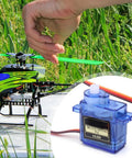 Four Pack 9g Micro Servo Motors For Arduino Projects with Metal Gears shown with helicopter setup in grass