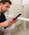 Man using Five In One Folding Hand Saw for drywall and more with quick change blades, cutting PVC pipe in bathroom