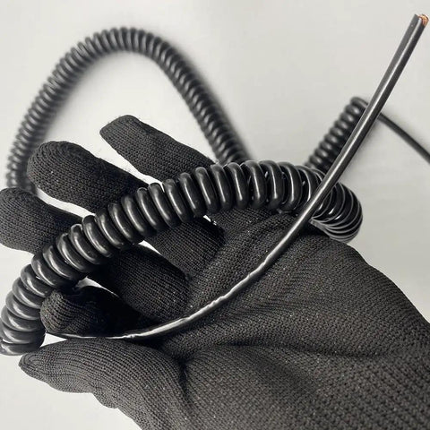 Rock Solid Coiled Power Extension Cord With Spring Wire Cable And Five Core Conductors shown in hand, black coiled design for easy use.