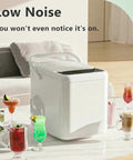 Electric Countertop Ice Maker Featuring Self Cleaning Tech And Rapid Bullet Cube Production In Just Six Minutes With A Nifty 12 Kilogram Daily Output That Slams On Any Counter Comes Packed With A Scoop And Basket For Dope Home Bartending Sessions on a counter next to colorful cocktails.