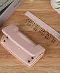Pink Two Hole Punch With Ruler One Quarter Inch Punch for file folders and looseleaf, manual low force, holds up to ten sheets.