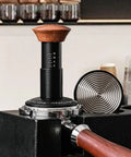 Heavy Hitter Spring Loaded Coffee Tamper With Precision Distribution Leveler And Clear Pressure Scale for espresso puck preparation.