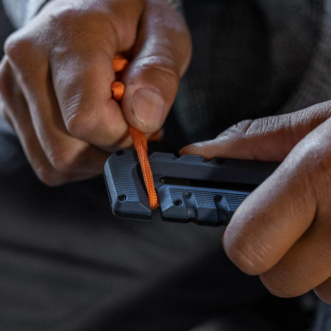 Blue Gerber Prybrid multi-tool with orange lanyard, close-up of grip area.