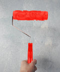 Professional Grade Slick Wood Grain Texture Paint Roller For Interior Wall Decoration with red rubber handle on wall.