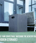 Free tank cover table on a patio, matching the wood-look desktop color, adjacent to an outdoor lounge chair, with hidden storage feature.