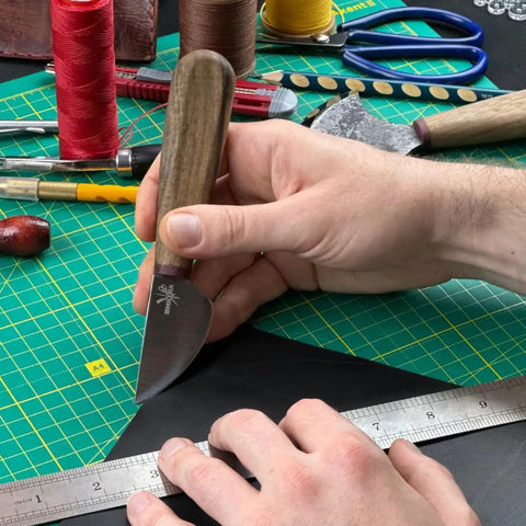 Person using Round Leather Knife For Cutting, Trimming, Skiving And Shaping Pro Grade High Carbon Steel Blade on black leather