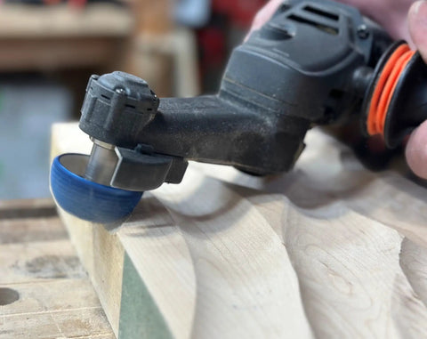 Close-up of Badass Two Inch Tungsten Carbide Contour Wheel For Die Grinders on wood for smooth shaping and material removal.