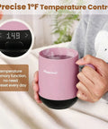 Smart Electric Heated Coffee Mug With Precision Temperature Setting And Rechargeable Coaster To Keep Your Daily Brew Piping Hot And Sipping Smooth On The Go 12 Oz Spill Resistant Travel Mug in pink held by a person with steam rising.