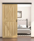 Six Foot Sliding Barn Door Hardware Track Kit With Handles In Black installed above a wooden door in a modern bedroom setting.