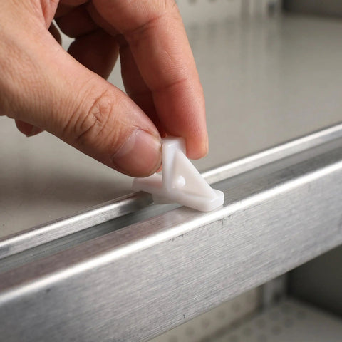 Hand installing No Mess Freezer Shelf Clips 10 Pack For Fridge Organization on metal fridge shelf.