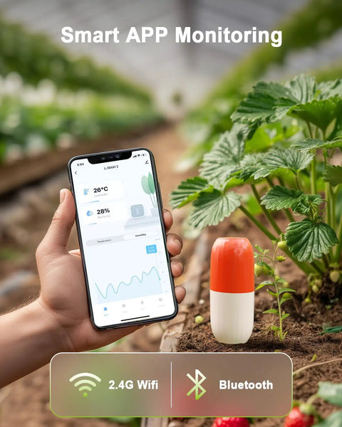 A hand holding a smartphone displaying an app, next to the 2-In-1 Wireless Soil Meter With WiFi And Bluetooth in a garden bed.