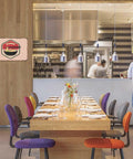 Vintage Ramen Sign Metal Wall Art 8x12 Tin Sign Poster hangs in a modern restaurant interior with colorful chairs.