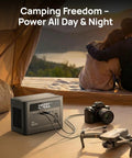 Portable Power Station With 700W Surge, 288Wh LiFePO4 Battery Backup powering camera and drone in a camping setup.