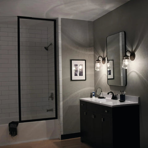 Architectural Bronze 1 Light Wall Sconce With Clear Seeded Glass illuminating modern bathroom with mirror reflection