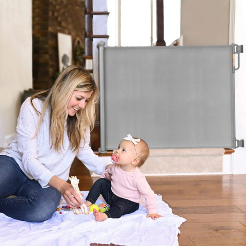 Mother with baby beside Retractable Baby Gate For Stairs And Doorways, 33 Inch Tall, Expands To 55 Inch Wide, Double Locking Safety gate.