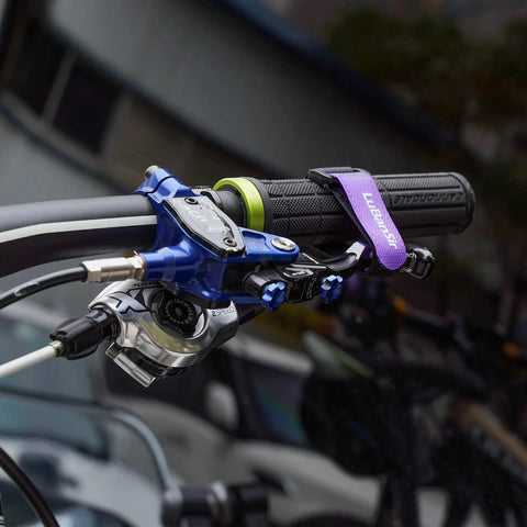 Close-up of bike handlebar with attached 8 Pack Bike Rack Straps With Adjustable Stabilizers, 8 Inch and 26 Inch Lengths.