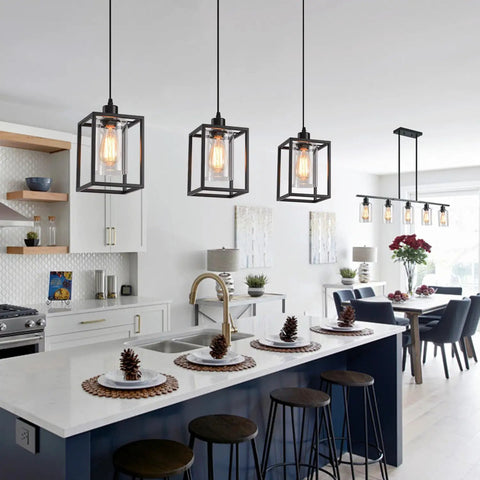Rock Solid Black Pendant Lights For Kitchen Island, 3 Pack Sleek Industrial Farmhouse Lanterns With Adjustable Height and Clear Glass Shade above a modern kitchen island.
