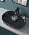 Matte Black Oval Vessel Sink 23.5 By 15.7 Inches, Ceramic Countertop Bathroom Basin With Pop Up Drain, water flowing into sink