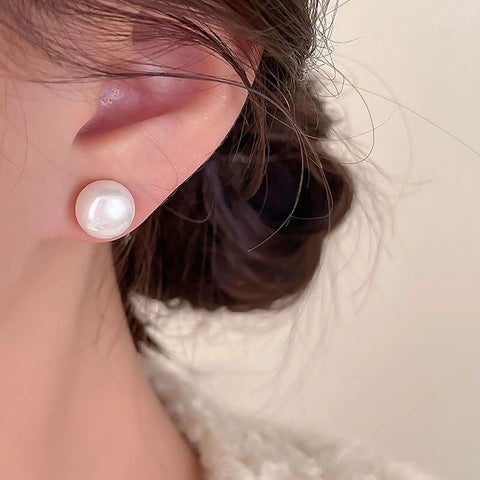 12 Pairs Hypoallergenic Pearl Stud Earrings Set For Women, white composite pearl stud earring shown on ear