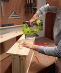 Person using Cordless AirStrike 23-Gauge Pin Nailer, 18-Volt One Plus, Headless Pin Nailing on wooden cabinet piece