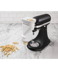 Gourmet Pasta Press Attachment for Stand Mixers with 6 Interchangeable Plates creating fresh fusilli pasta in kitchen setting