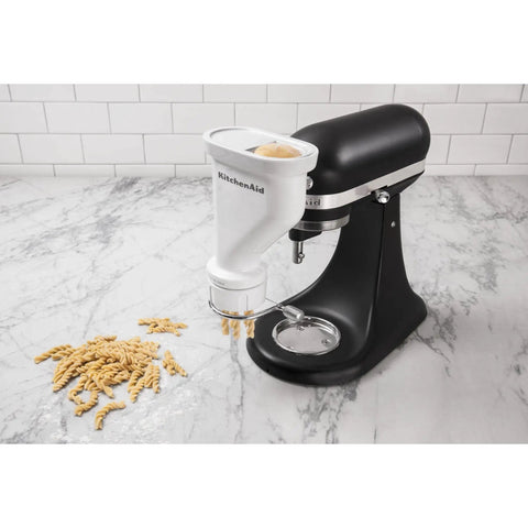 Gourmet Pasta Press Attachment for Stand Mixers with 6 Interchangeable Plates creating fresh fusilli pasta in kitchen setting
