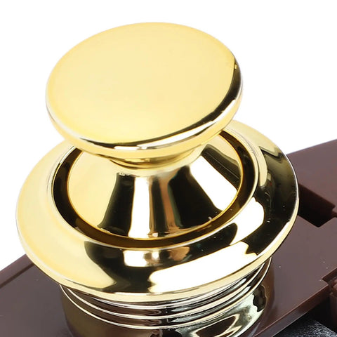 Gold cabinet push button latch with smooth finish, brown base for RV yacht motorhome caravan, close-up view.