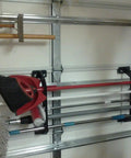 Garage Door Organizer Rack for Fishing Gear and Tools 18 Inch ABS Plastic Rod Holder mounted on a garage door with brooms and tools