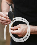 Heavy Duty Manual Oil Transfer Pump With Thick Plastic Siphon Tube for Effortless Fluid Extraction And Gas Cleanup, held with a flexible siphon tube.