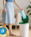 Woman placing a blue disposable bed pad in a green trash bin, promoting cleanliness for Top Shelf Extra Large Disposable Bed Pads Designed To Quickly Absorb And Lock Fluid Without Leaking For Adult Incontinence Or Puppy Training Heavy Duty Super Absorbent Underpads Keep Bedding Pristine And Fresh Daily.
