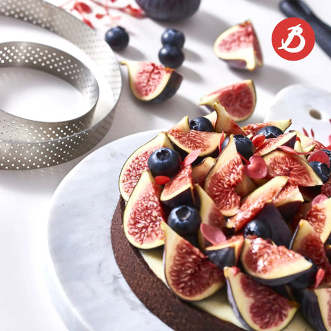 Perforated Round Tart Ring 11.25 Inch Diameter 0.8 Inch Height For Golden Crispy Tart Shells next to a fruit-topped chocolate tart