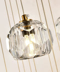 Close-up of Modern Raindrop Pendant Lights Set Of 3, featuring brass round hanging lamps with clear crystal prisms, lit bulbs visible